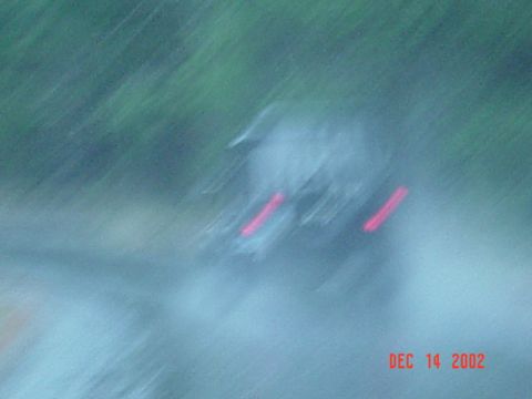 1989 Ford Bronco - The photo shows a blurry rear view of a vehicle with its taillights illuminated, dated December 14, 2002.