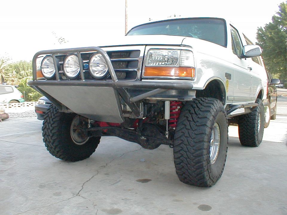 White Ford Bronco with custom bumper and off-road tires, front view