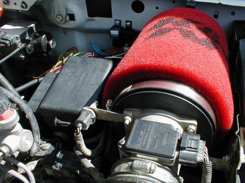 1996 Ford Bronco - Close-up of a vehicle's engine bay, focusing on the air intake and fuse box.