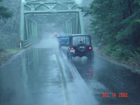 1989 Ford Bronco - A convoy of vehicles drives through a tunnel-like bridge on a rainy day in December 2002.