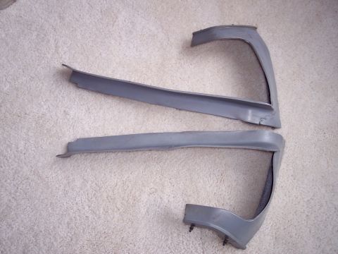 1968 Chrysler Town & Country - Pair of bumper trim pieces, possibly for a classic car, laid out on a carpet.