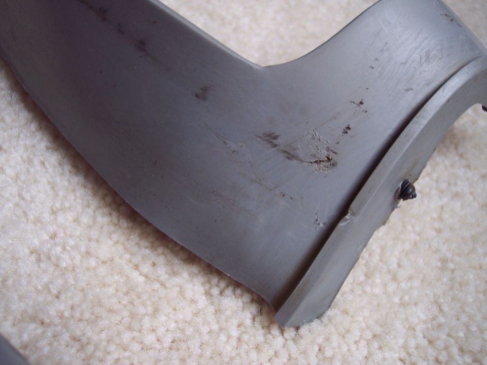 Close-up of scuffed grey A-pillar trim panel base with black push-in retaining clip