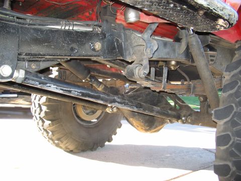 1970 Ford Bronco - Close-up view of the suspension and undercarriage components of a red vehicle.