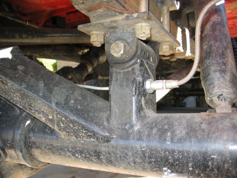 1970 Ford Bronco - Close-up view of the rear axle and suspension system, showing a braided brake line and shock absorber.