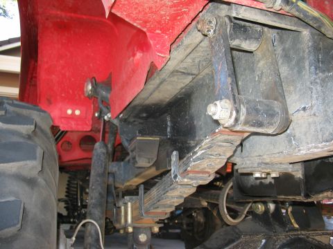 1970 Ford Bronco - Close-up view of the undercarriage and suspension system of a red vehicle.