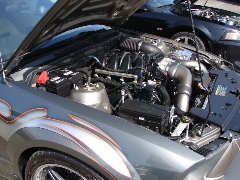 1992 Ford Taurus - The engine bay of a custom car with flame decals is shown, with another vehicle in the background.