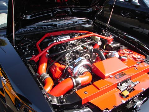 1992 Ford Taurus - Customized engine bay a prominent turbocharger and vibrant red and orange performance parts.