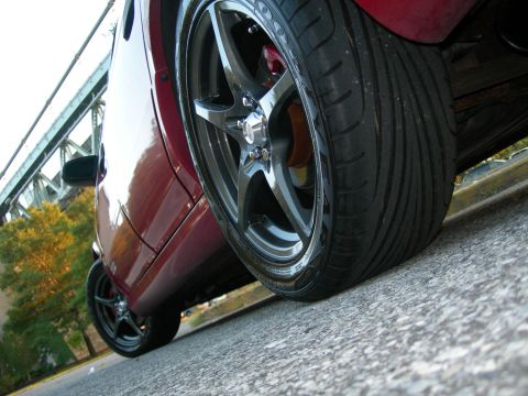 1992 Ford Taurus - Custom wheels and tires on a red car, photographed near a bridge. Supermotors.net watermark visible.