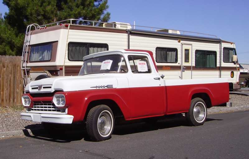 1959 Ford F-series pickup truck parked in front of an RV