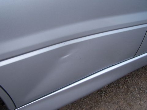 1995 Ford Probe - A close-up view of a dent on the side of a silver vehicle, with a watermark at the bottom right.