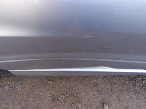 1995 Ford Probe - Gray car door with a dent and chrome trim piece visible.