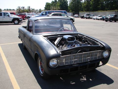 1992 Ford Taurus - This customized pickup truck features a prominent exposed engine and a red interior, with its body style suggesting a 1960s model.