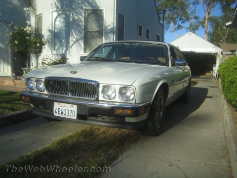 1968 Ford Mustang - This white Jaguar sedan is parked in a residential driveway, showing its front 3/4 view.