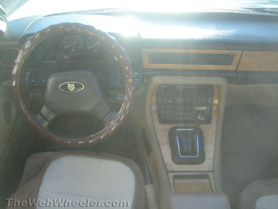Jaguar interior with wood trim, leather steering wheel, and automatic shifter