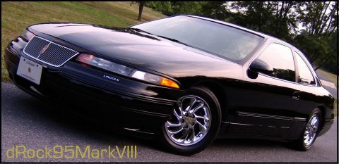 1996 Mercury Grand Marquis - A black Lincoln Mark VIII coupe is shown from a low front three-quarter angle on a paved road.