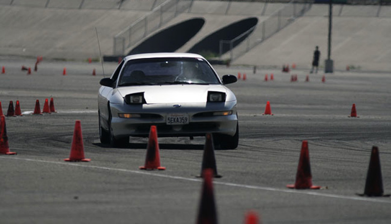 Silver 1993 Ford Probe with pop-up headlights navigating an autocross course