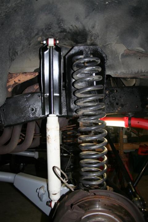 1978 Ford Bronco - The image shows a close-up view of a vehicle's suspension system, focusing on the shock absorber and coil spring.