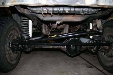 1978 Ford Bronco - The steering linkage and front suspension components of a vehicle are visible from below.
