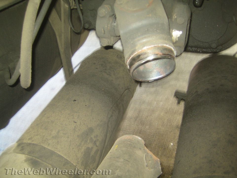 Driveshaft slip yoke between two black bushings under a vehicle