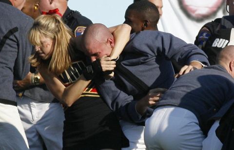 1986 Ford Bronco - A group of people, some in uniform and one in a cheerleader outfit, are involved in a physical altercation.