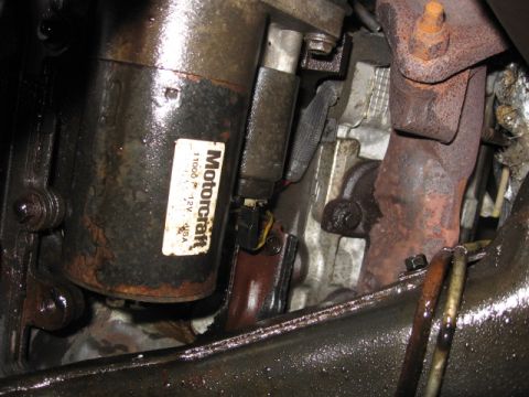1992 Ford Crown Victoria - Close-up of a starter motor and exhaust manifold, showing engine components.