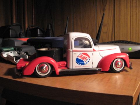 1992 Ford Crown Victoria - A toy truck with a Pepsi logo is displayed on a wooden table, with electronic devices in the background.