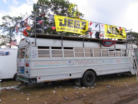 1998 GMC Sierra 1500 - This bus is decorated with banners and graffiti, including "Jegs" and "Margaritaville" slogans.