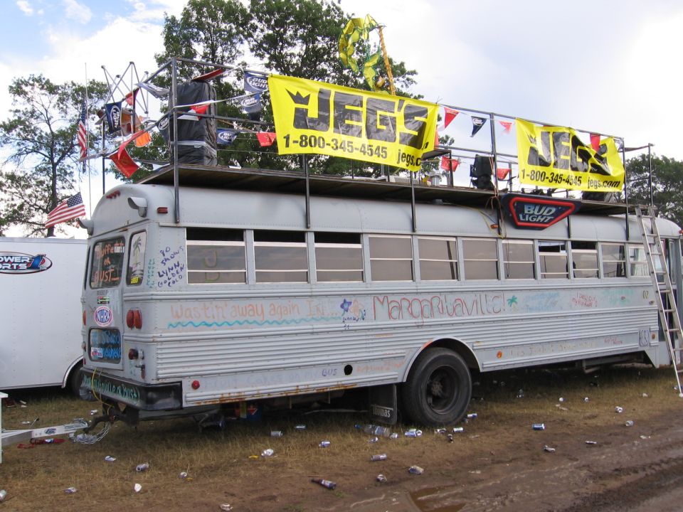 Side view of a decorated bus with "Jegs" banners and "Margaritaville" graffiti