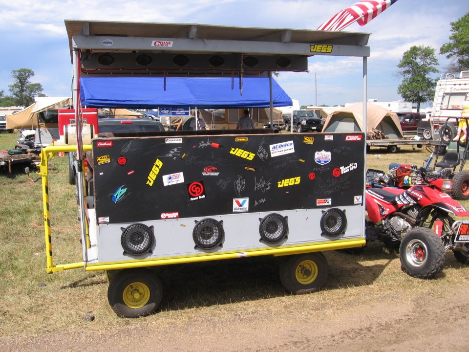 Custom trailer with speakers, JEGS stickers, and an American flag overhead