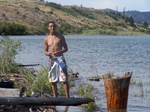 1994 Ford Probe - A man poses for a photo while standing in the water near the shore of a lake, with a wooded hillside in the background.