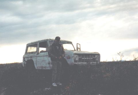 1978 Ford Bronco - A man poses next to a weathered 1978 Ford Bronco in an outdoor setting.