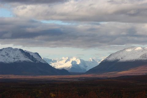 1978 Ford Bronco - A vast landscape snow-capped mountains and a valley with fall colors under a dramatic sky.