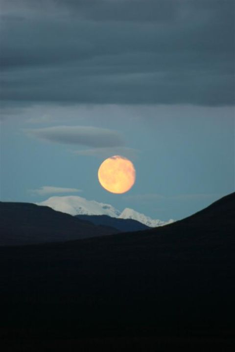 1978 Ford Bronco - A full moon ascends over a mountainous landscape, casting a warm glow against the twilight sky.