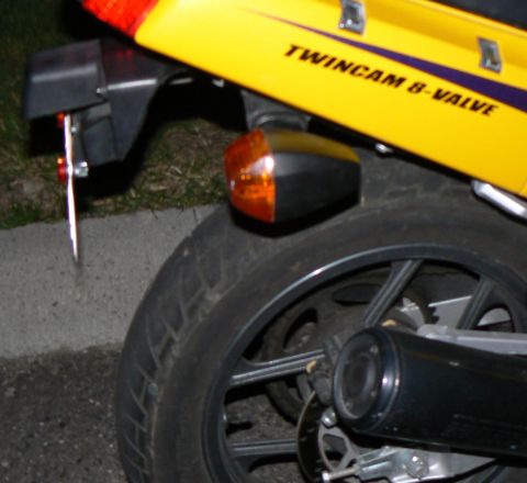 2002 Kawasaki Ninja - A yellow motorcycle's rear section is visible, showing the fender, turn signal, and exhaust.
