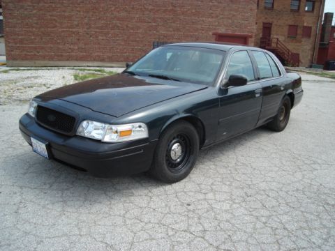 2000 Ford Crown Victoria - A dark green 2000 Ford Crown Victoria sedan is viewed from the front three-quarter angle, parked outdoors.