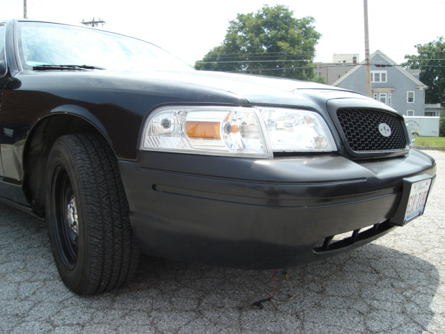 Black 2000 Ford Crown Victoria front end with a honeycomb grille and clear headlights