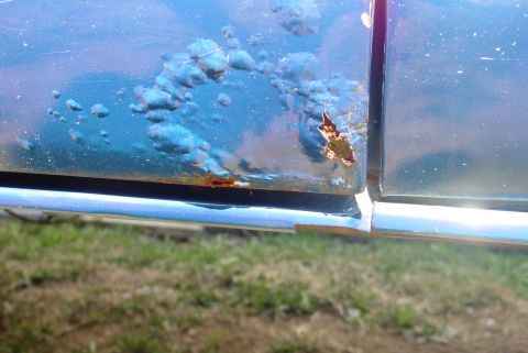 1993 Ford Bronco - Rust is actively consuming the lower portion of this blue vehicle's door panel.