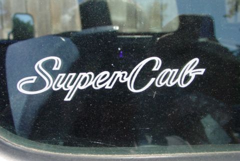 1993 Ford Bronco - A sticker indicating 'SuperCab' is applied to the window of a vehicle.