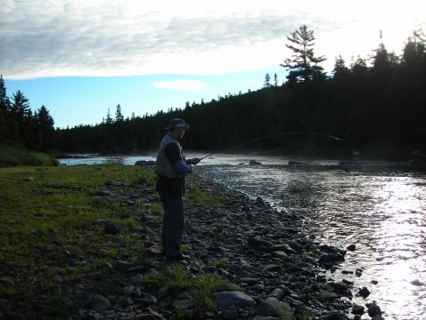 1984 Ford Bronco - A lone angler casts a line into a , misty river at sunrise, likely, dawn or dusk.