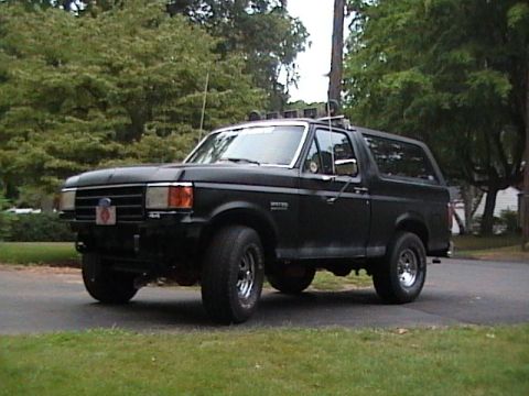 1990 Ford Bronco - A black 1990 Ford Bronco is shown from a three-quarter front view, parked outdoors.
