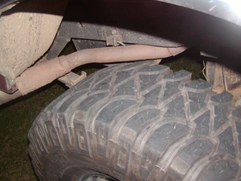 1991 Ford Bronco - Close-up view of a vehicle's tire and exhaust system, with visible rust on-screen text from Supermotors.net.