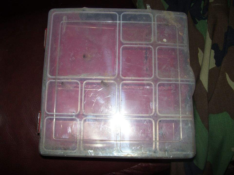 Plastic organizer box with multiple compartments, some red dividers visible