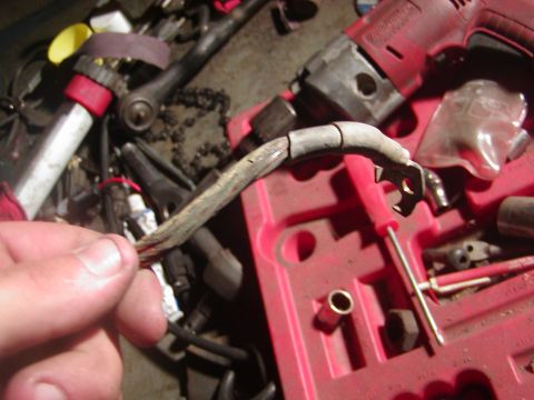 1991 Ford Bronco - A close-up shows a worn wire harness, likely needing replacement, amidst various tools.