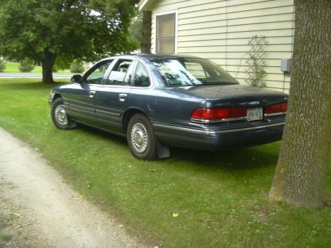1996 Ford Crown Victoria - A 1996 Ford Crown Victoria is parked on a grassy lawn next to a house.