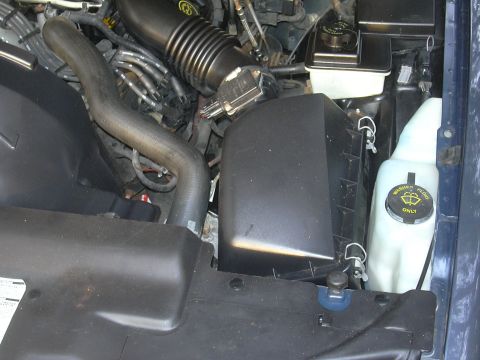 1996 Ford Crown Victoria - Close-up of an engine bay, focusing on the air intake system and fluid reservoirs.
