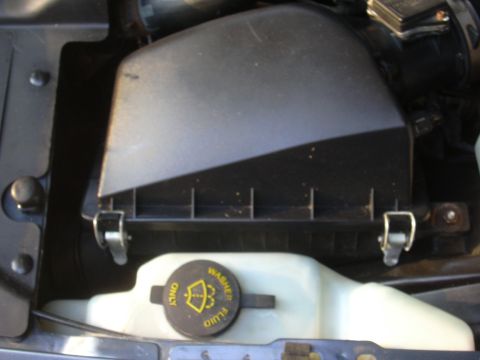 1996 Ford Crown Victoria - The engine air filter housing and washer fluid reservoir cap are visible in this close-up engine view.