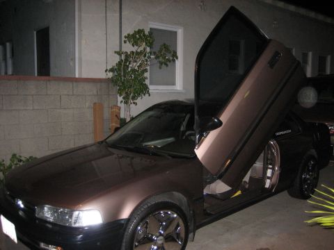 1968 Ford Mustang - Customized sedan with upward-opening doors, parked outdoors at night.