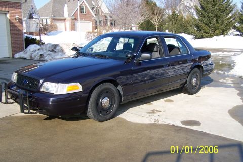 2003 Ford Crown Victoria - This Ford Crown Victoria police car is parked outside a house in snowy conditions.