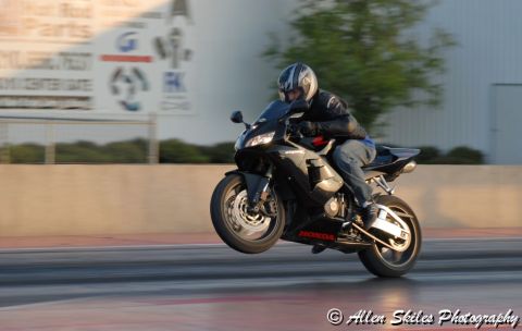 2006 Honda CBR-RR - A rider on a black 2006 Honda CBR-RR performs a wheelie at a drag strip.