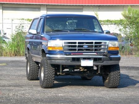1996 Ford Bronco - This blue 1996 Ford Bronco is shown from the front with its lifted suspension and large off-road tires.